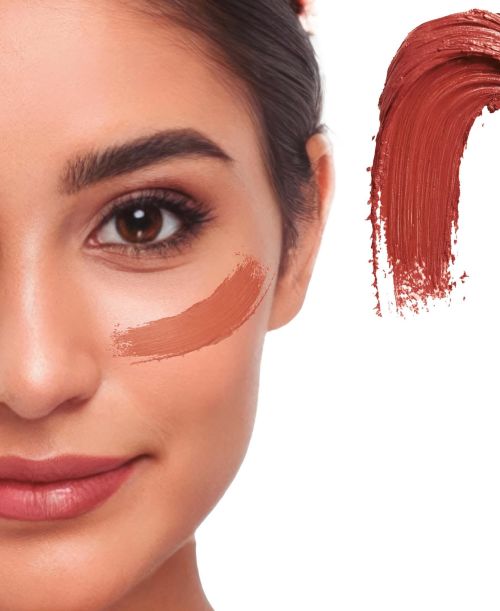 Detaillierte Nahaufnahme eines Gesichts mit einem cremigen Klecks des Creme Make-ups in der Farbe braun als Farbmuster für Fasching oder Halloween.