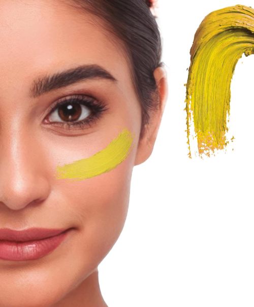 Detaillierte Nahaufnahme eines Gesichts mit einem cremigen Klecks des Creme Make-ups in der Farbe gelb als Farbmuster für Fasching oder Halloween.