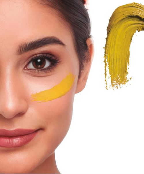 Detaillierte Nahaufnahme eines Gesichts mit einem cremigen Klecks des Creme Make-ups in der Farbe gold als Farbmuster für Fasching oder Halloween.