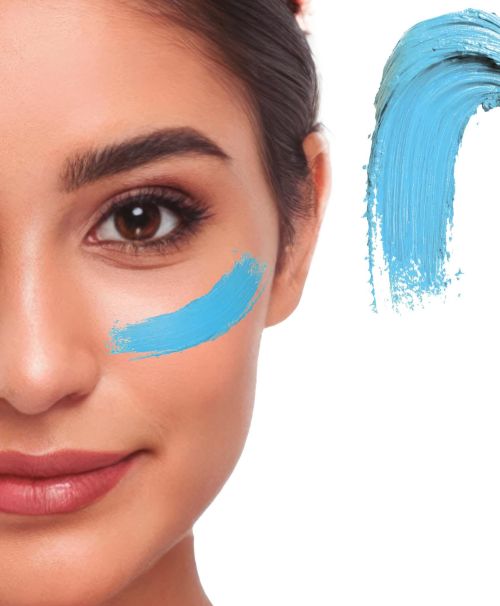 Detaillierte Nahaufnahme eines Gesichts mit einem cremigen Klecks des Creme Make-ups in der Farbe hellblau als Farbmuster für Fasching oder Halloween.