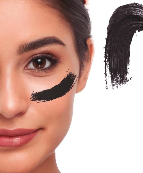 Detaillierte Nahaufnahme eines Gesichts mit einem cremigen Klecks des Creme Make-ups in der Farbe schwarz als Farbmuster für Fasching oder Halloween.