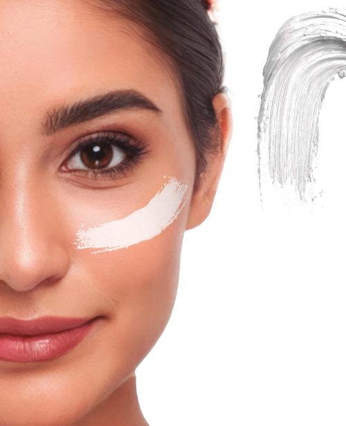 Detaillierte Nahaufnahme eines Gesichts mit einem cremigen Klecks des Creme Make-ups in der Farbe weiss als Farbmuster für Fasching oder Halloween.