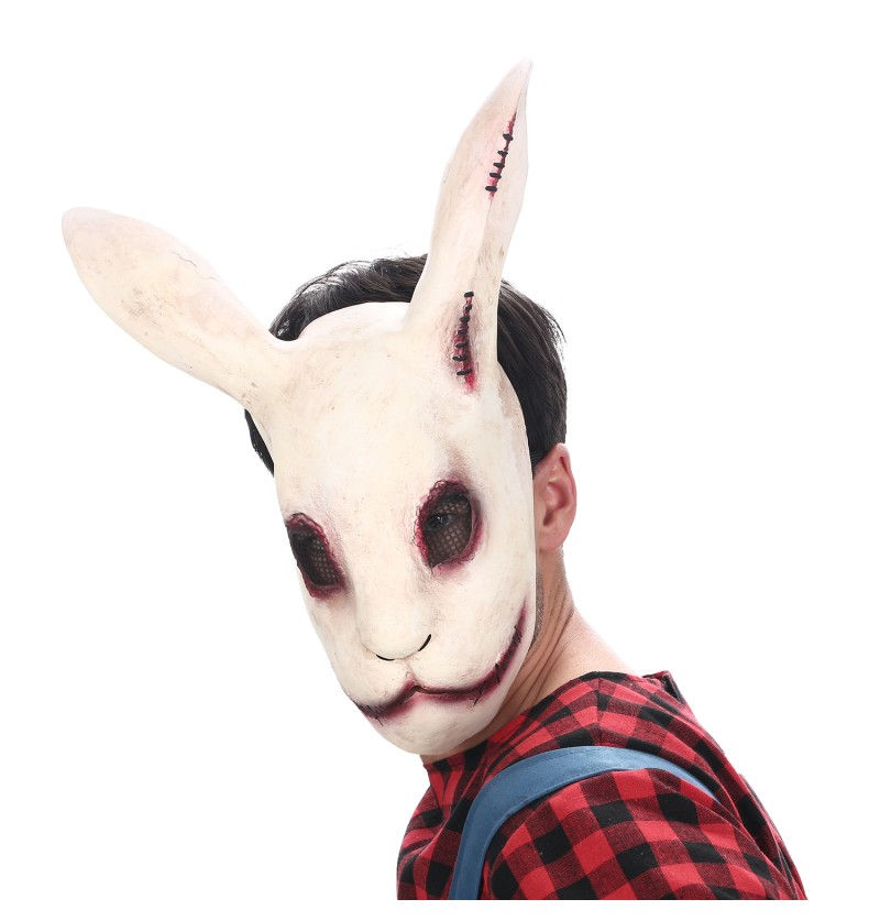 Eine furchteinflößende, weiße Horrorhasen-Maske aus Latex mit unheimlichen Details und einem bösen Gesichtsausdruck, die in den Verkaufsregalen eines Berliner Maskenladens präsentiert wird.