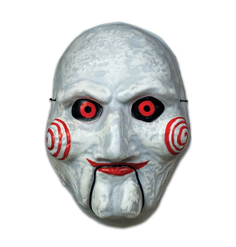 Eine detailgetreue Plastikmaske der Horrorpuppe Billy aus "Saw" mit den markanten roten Spiralen auf den weißen Wangen und den roten Augen, die in den Verkaufsregalen eines Berliner Halloween-Shops präsentiert wird.