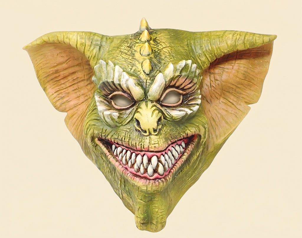Eine grüne, furchteinflößende Monster-Maske aus Latex mit unheimlichen Details, die in den Verkaufsregalen eines Berliner Kostümladens präsentiert wird.